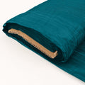 Teal fabric roll with textured finish on a white background