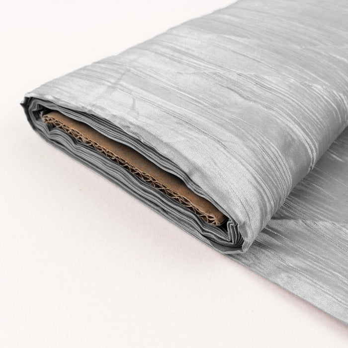 Silver textured fabric roll on a plain background.