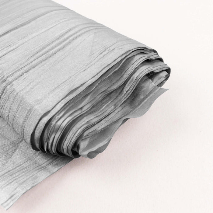 Silver textured fabric roll on a soft background.