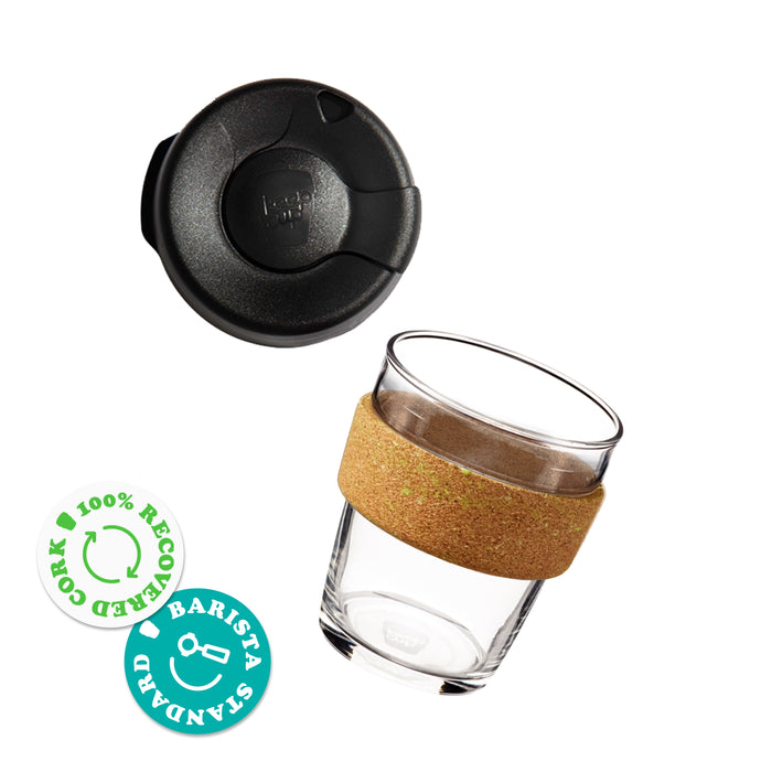 Brew Cork Ace M 12oz reusable coffee cup shown with black lid separated from the clear glass cup featuring a natural cork band, alongside badges indicating 100% recovered cork and barista standard compatibility.