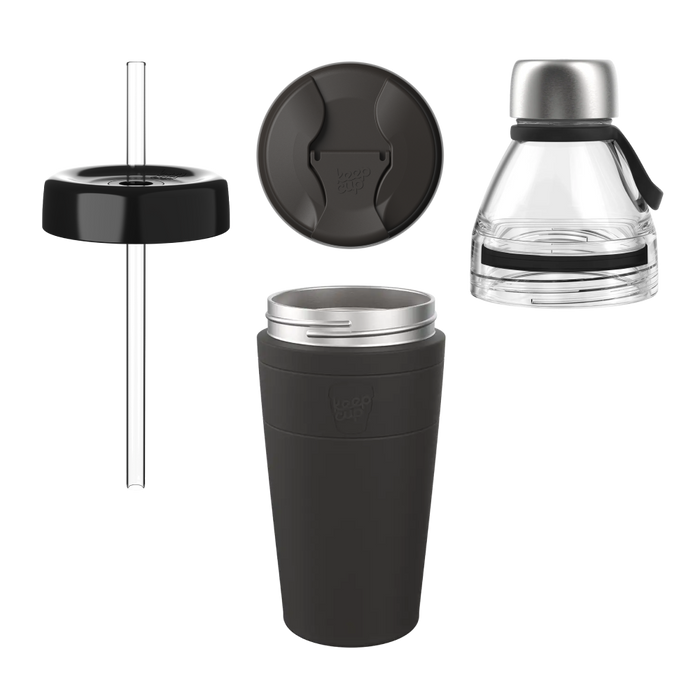 Exploded view of the KeepCup All Day Everyday in Black, showing four components: a dark grey insulated cup with stainless steel rim and KeepCup logo, a matching grey sipper lid, a black straw lid with plastic straw, and a clear glass tea infuser with stainless steel cap.