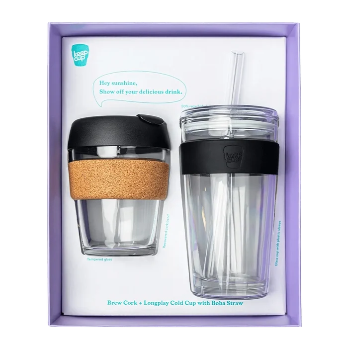 KeepCup Booked & Busy gift set in Black, featuring a Brew Cork reusable coffee cup with tempered glass and cork band alongside a Longplay Cold Cup with boba straw, displayed in lavender presentation packaging.