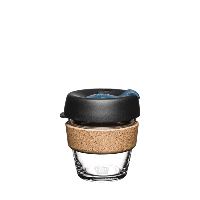 KeepCup Brew Cork XS 6oz in Storm colour, featuring a clear glass cup with natural cork band and charcoal lid with blue accent, shown against a plain white background.