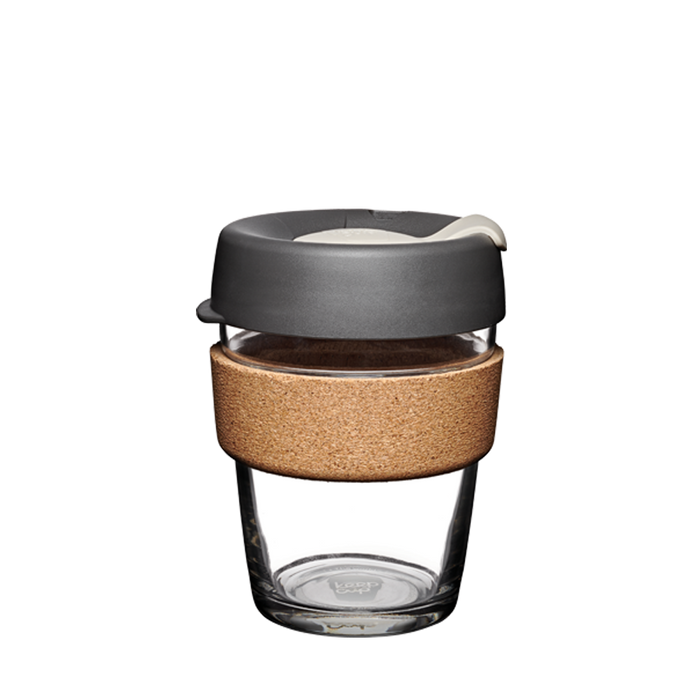 KeepCup Brew Cork M 12oz in Press colour, featuring a tempered glass cup with natural cork band and charcoal grey lid with cream-coloured plug, shown against a plain white background.