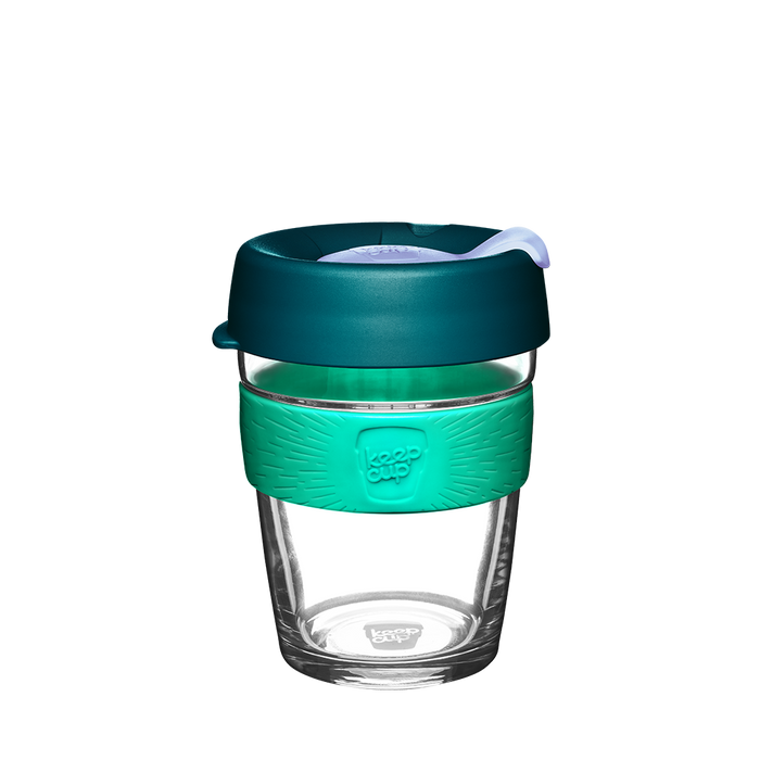 KeepCup Brew M 12oz in Eventide, featuring a clear glass cup with a teal silicone band embossed with the KeepCup logo, topped with a deep teal lid and light-coloured sipper plug, shown against a plain white background.