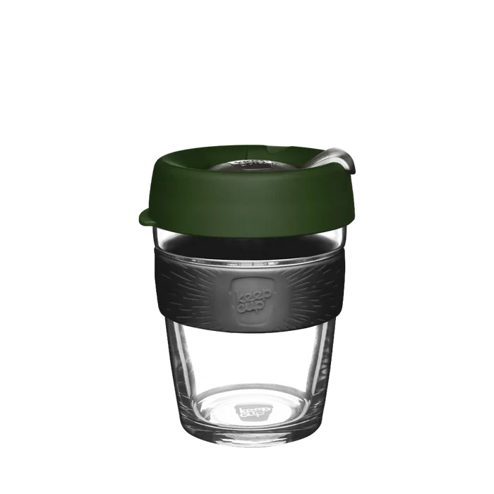 KeepCup Brew M 12oz in Pine, featuring a clear glass cup with dark charcoal silicone band and deep green lid with sipper closure, shown against a white background.