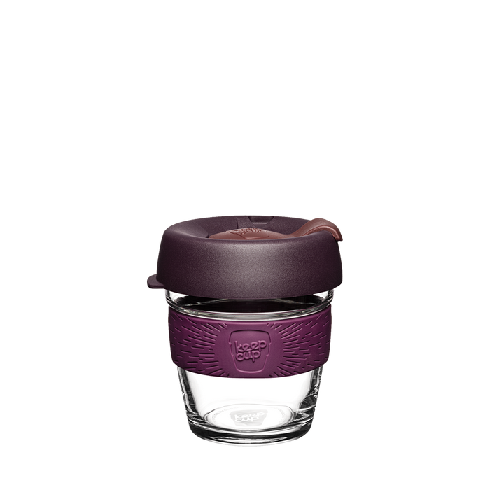 KeepCup Brew XS 6oz in Alder, featuring a clear tempered glass cup with a deep plum silicone band and matching dark purple lid with sipper opening, shown against a white background.