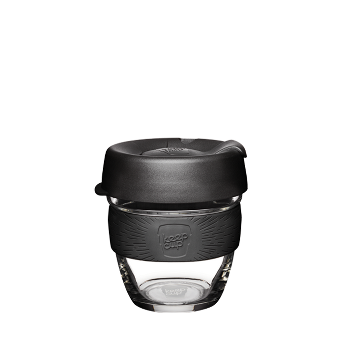 KeepCup Brew S 8oz in Black, featuring a clear glass cup with a charcoal silicone band embossed with the KeepCup logo and a black press-fit lid with sipper opening, shown against a white background.
