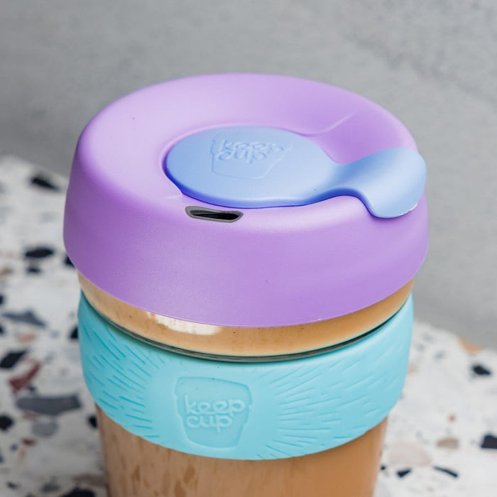 KeepCup Brew S 8oz in Moonlight, featuring a lavender lid with blue sipper plug and light blue silicone band, filled with a creamy coffee and placed on a terrazzo surface.