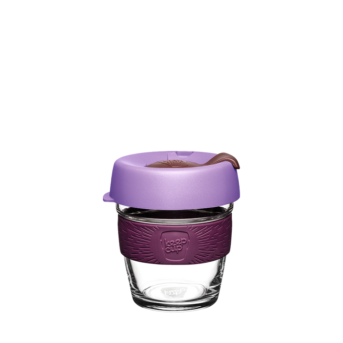 KeepCup Brew XS 6oz in Vanda, featuring a clear tempered glass cup with a deep plum silicone band and light lavender lid with sipper plug, shown against a white background.