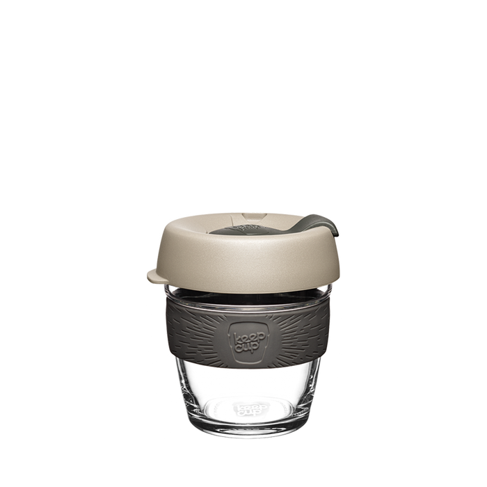 KeepCup Brew XS 6oz in Filter colour, featuring a clear tempered glass cup with dark grey silicone band and light beige lid with sipper, shown against a white background.