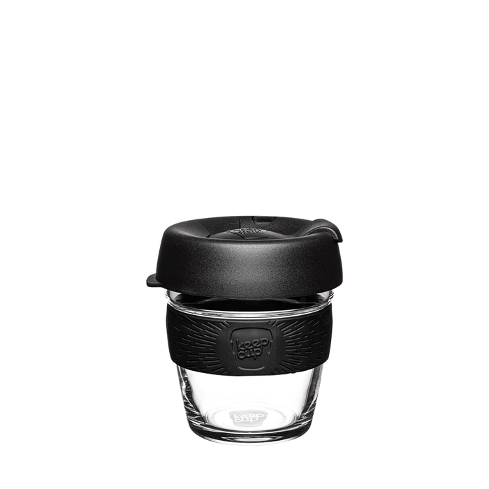 KeepCup Brew XS 6oz in Black, featuring a clear tempered glass cup with black silicone band and black plastic lid with sipper, shown front-on against a white background.