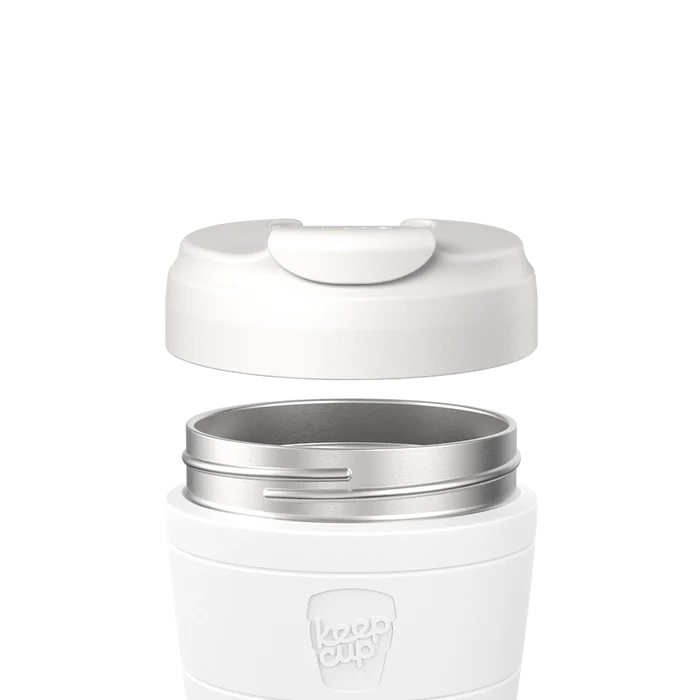 KeepCup Commuter Flip Lid in Bone shown hovering above a matching Bone-coloured cup, displaying the stainless steel rim and flip closure mechanism in an exploded product view.