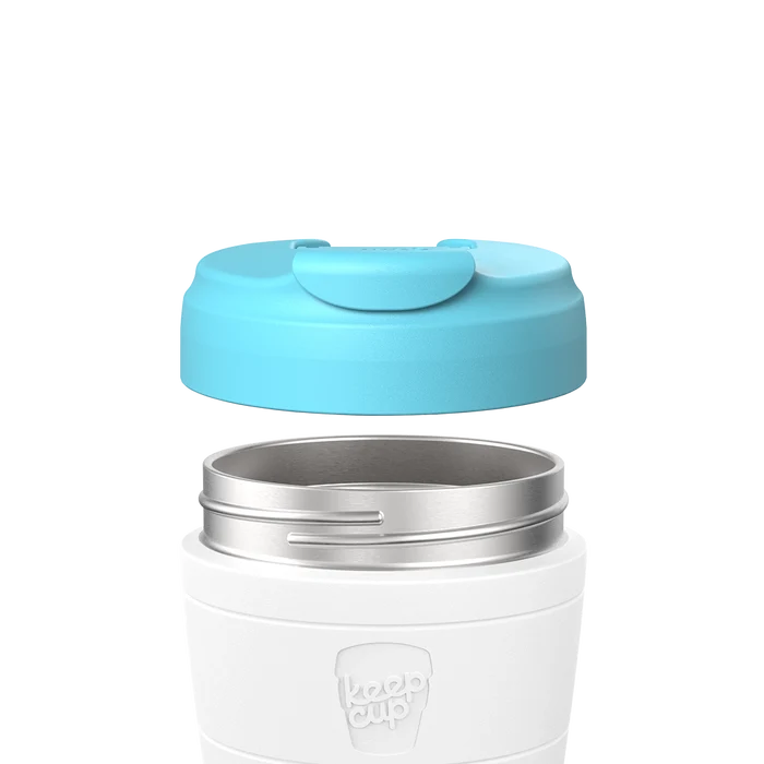 KeepCup Commuter Flip Lid in Cloud colour shown separated from a white reusable cup, displaying the light blue lid hovering above the stainless steel rim to demonstrate how the components fit together.