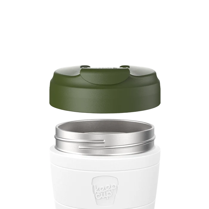 Exploded view showing the KeepCup Commuter Flip Lid in Pine hovering above a white reusable cup, displaying the olive green lid separated from the stainless steel rim and cup body with embossed KeepCup logo.