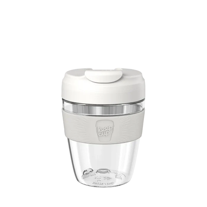KeepCup Commuter Light M 12oz in Bone, featuring a clear lightweight plastic cup with white lid and light grey silicone band, shown against a plain white background.