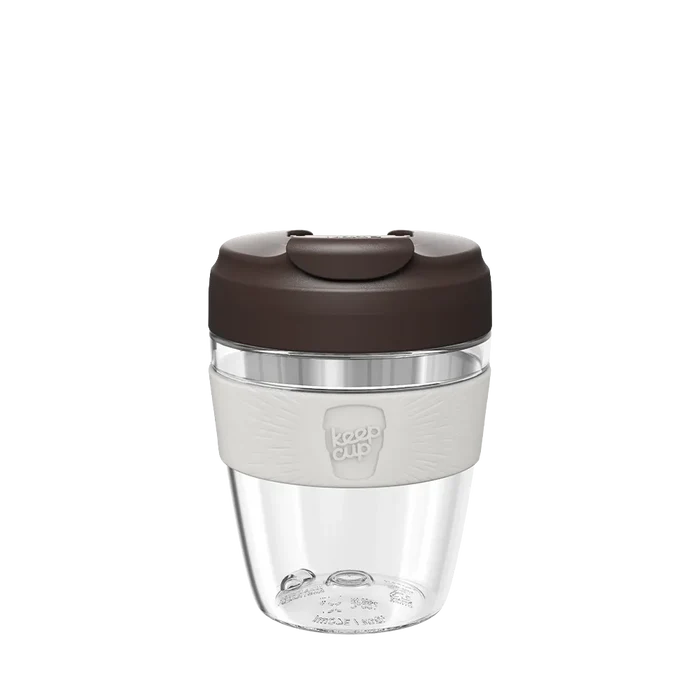 KeepCup Commuter Light M 12oz in Chocolate, featuring a clear lightweight plastic cup with a dark brown plastic lid and light grey band displaying the KeepCup logo, shown against a plain white background.