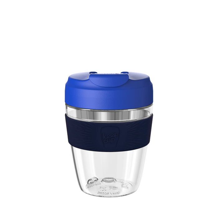 KeepCup Commuter Light M 12oz in Electric Ink, featuring a clear lightweight plastic cup with dark navy silicone band and bright blue lid, shown against a white background.