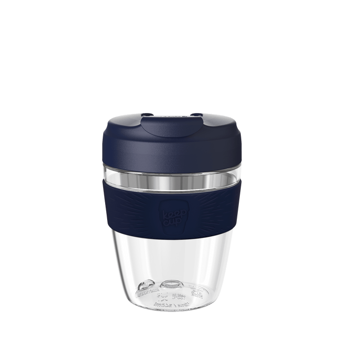 KeepCup Commuter Light M 12oz in Ink, featuring a clear lightweight plastic cup with navy blue silicone band and matching navy lid with sipper closure, shown against a white background.