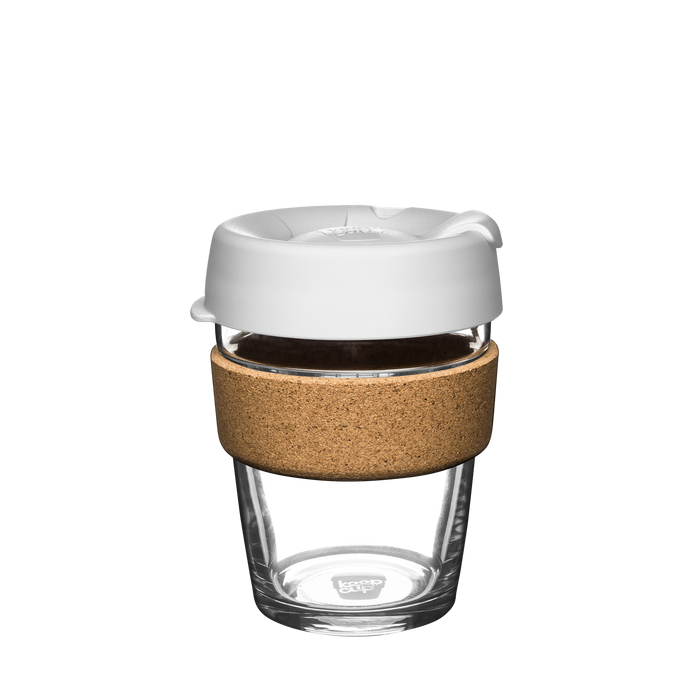 KeepCup Brew Cork M 12oz in white, shown on a plain background. The reusable glass cup features a white lid with a sip opening, a natural cork band for insulation, and clear tempered glass body.