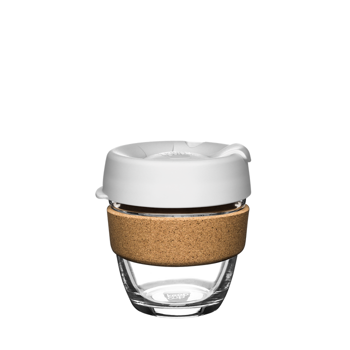 A Design Your Own Brew Cork reusable coffee cup featuring a clear tempered glass body, natural cork band for grip and insulation, and a white silicone lid with a closable drinking spout, shown against a plain white background.