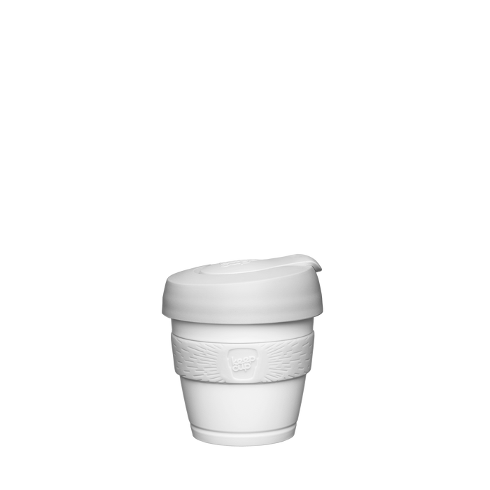 A Design Your Own Original XXS 4oz KeepCup in all-white, featuring a white plastic cup, matching white silicone band with embossed KeepCup logo, and white lid with sipper closure, shown against a plain white background.