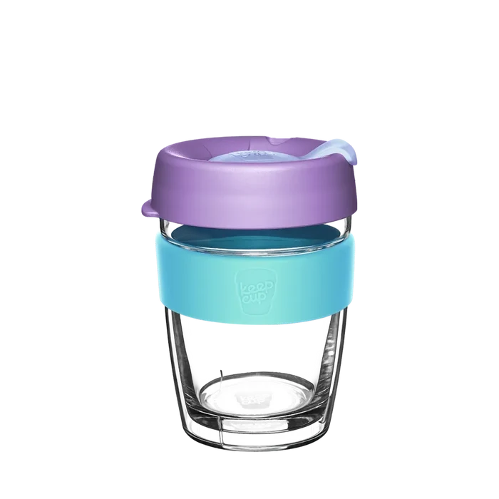 KeepCup Brew Longplay M 12oz in Moonlight, featuring a double-walled glass cup with a light blue silicone band and lavender-coloured lid with sipper closure, shown against a white background.