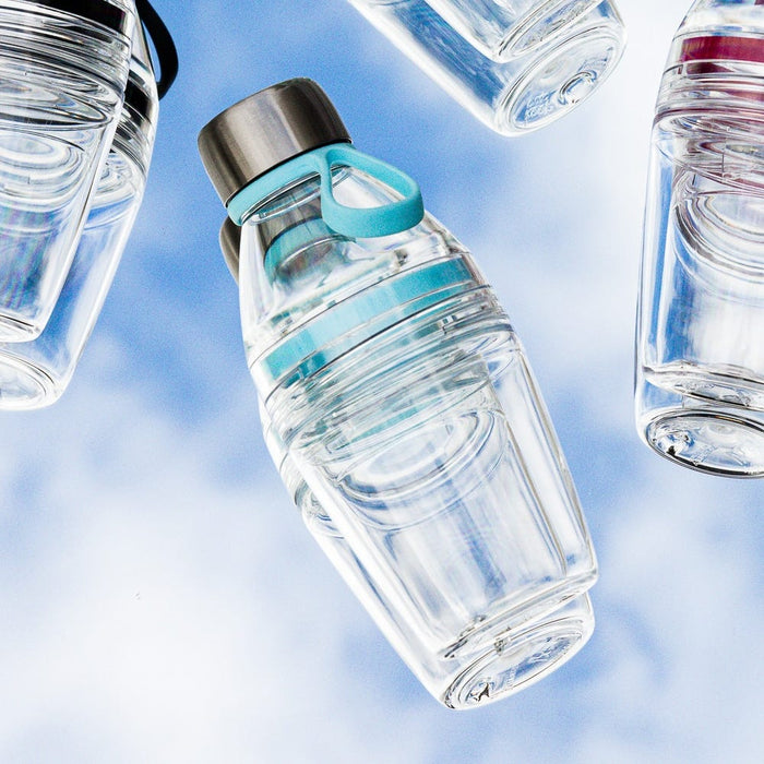 KeepCup Glow Getter in Cloud colourway floating against a soft blue sky background, showcasing the clear reusable bottle with turquoise accents and stainless steel lid, surrounded by additional bottles at various angles.