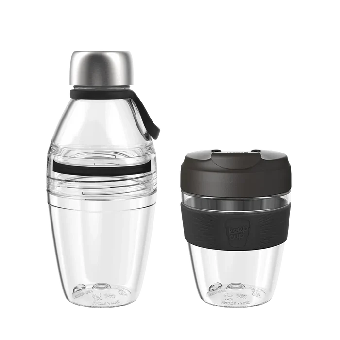 KeepCup Glow Getter Black set featuring a clear reusable water bottle with stainless steel cap and carry loop alongside a matching clear reusable coffee cup with black lid and silicone band, both shown against a white background.