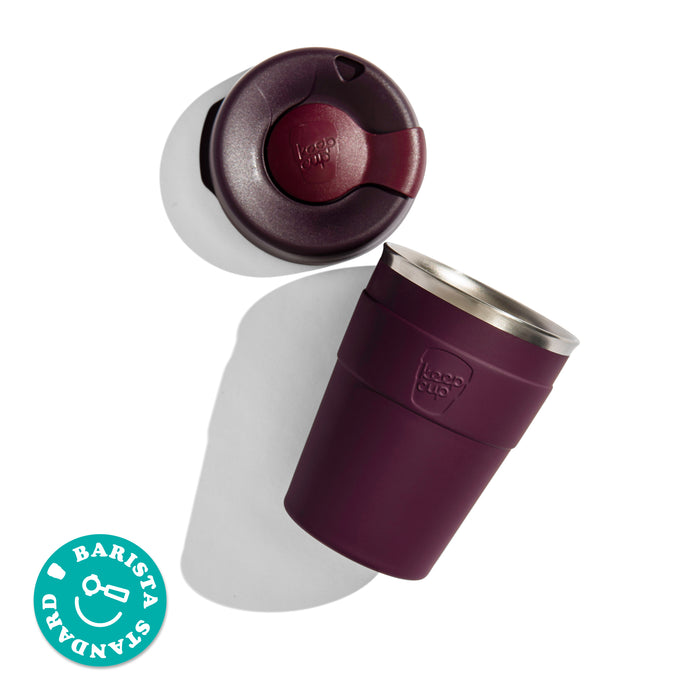 KeepCup Thermal M 12oz stainless steel reusable cup shown at an angle with its lid removed, displaying the press-fit closure and drinking hole. Features a Barista Standard badge in the corner.