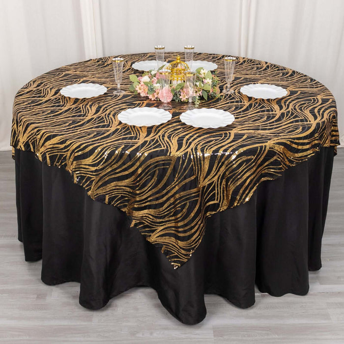 Gold wave patterned tablecloth draped over round table with white plates.