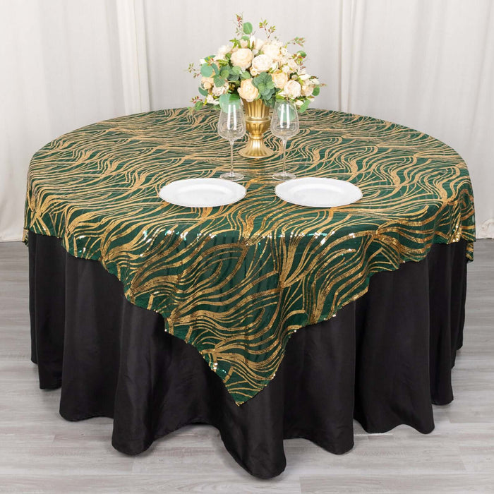 Elegant green and gold wave-patterned tablecloth draped over a round table.