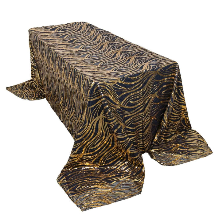 Gold and black wavy patterned tablecloth on a table.