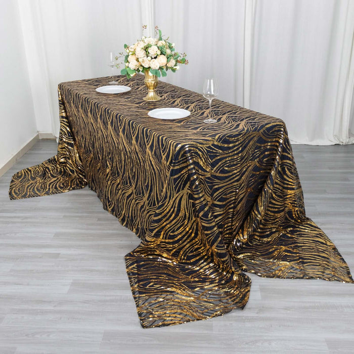 Elegant black and gold patterned tablecloth on a dining table with floral centerpiece.