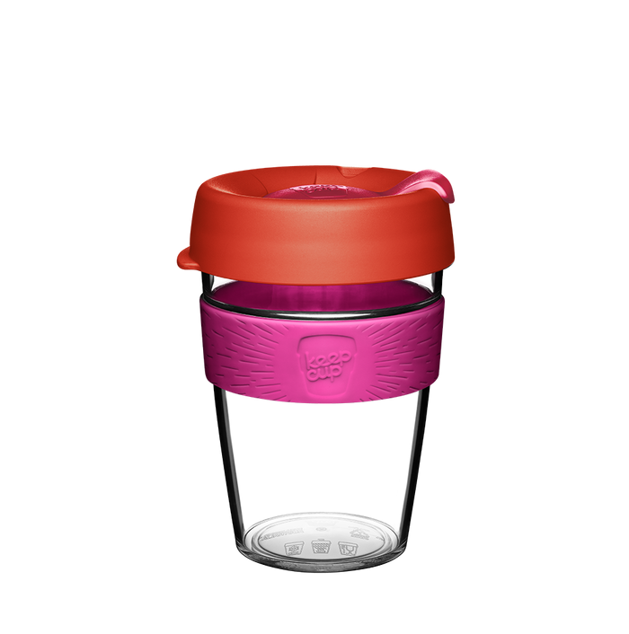 KeepCup Original Clear M 12oz in Daybreak, featuring a clear plastic cup with a bright pink silicone band and coral-coloured lid with sipper closure, shown against a white background.