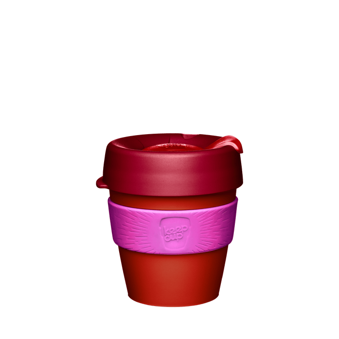 KeepCup Original S 8oz in Daybreak, featuring a red-orange cup body, pink silicone band with embossed KeepCup logo, and dark red lid with sipper closure, shown against a white background.