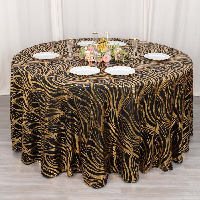Elegant black and gold patterned tablecloth on a round table with decorative items.