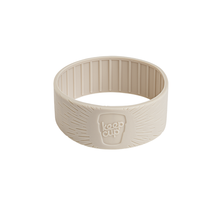 KeepCup Silicone Band in Latte colour, shown at a three-quarter angle displaying the textured exterior with radiating line pattern, embossed KeepCup logo, and ribbed interior grip.