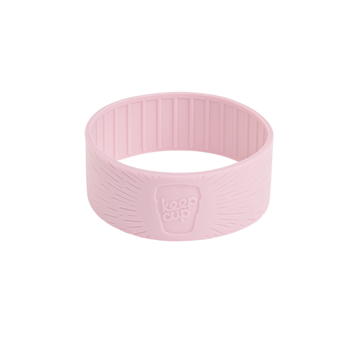 Pashmak pink silicone band for KeepCup shown at a slight angle on a white background, featuring the embossed KeepCup logo and radiating line texture on the exterior with vertical ridges on the interior for grip.