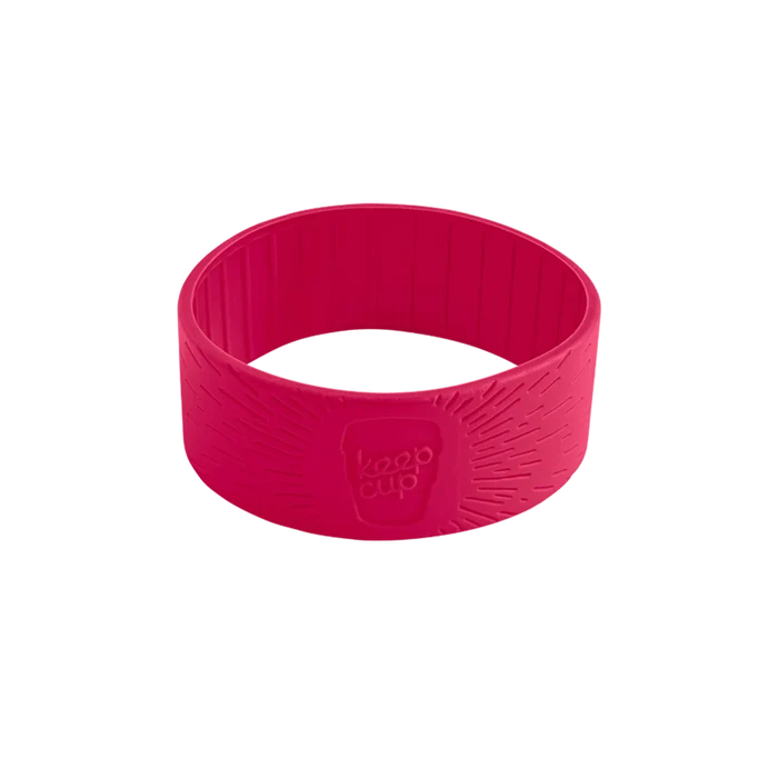 A pink silicone band for KeepCup reusable cups, shown at a slight angle against a white background. The band features a textured grip pattern with radiating lines and an embossed KeepCup logo.