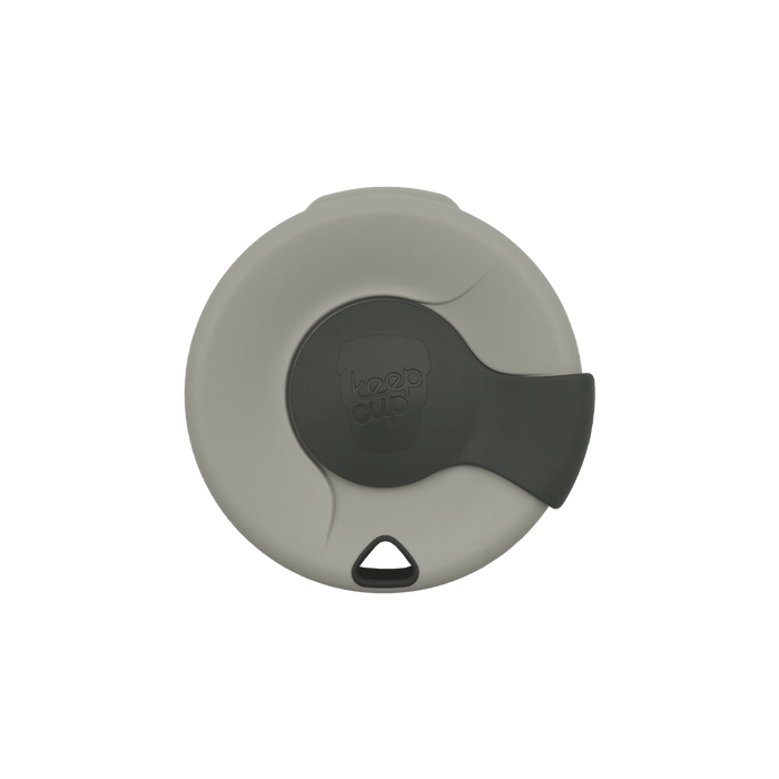 Top-down view of a KeepCup Splashproof Lid in light grey with a dark grey sliding closure featuring the embossed KeepCup logo, and a small triangular drinking hole at the bottom edge.