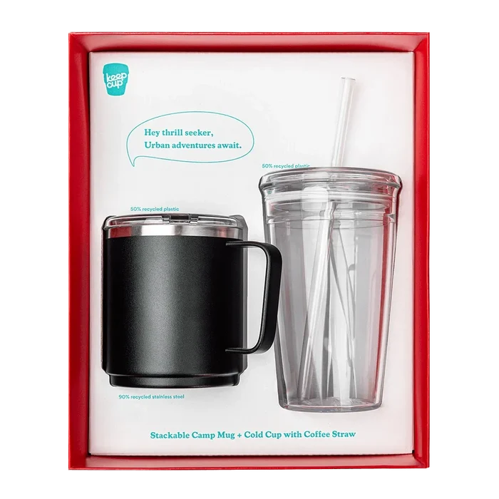 KeepCup Urban Adventurer gift set in black, featuring a stackable camp mug in black stainless steel with clear lid alongside a clear cold cup with straw, displayed in red presentation box with product callouts noting recycled materials.